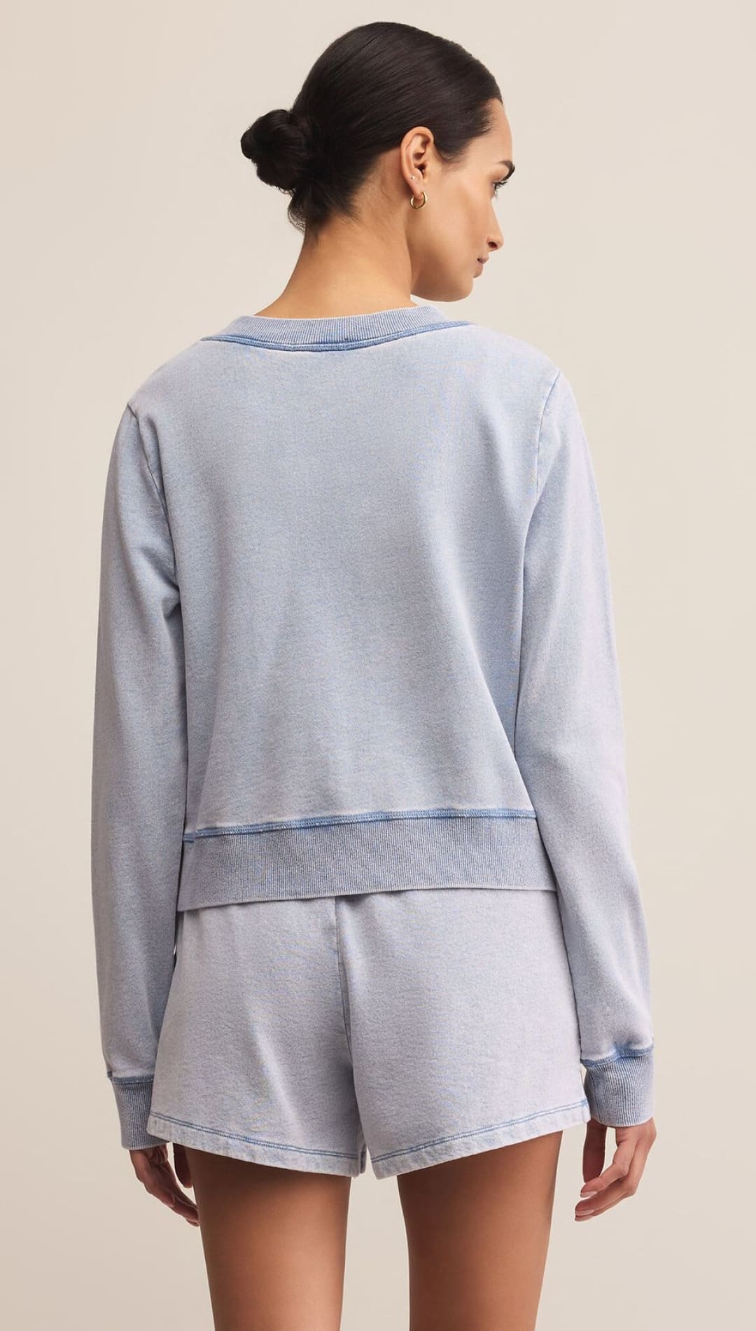A light blue women’s loungewear set consisting of a long-sleeved sweatshirt and shorts.
