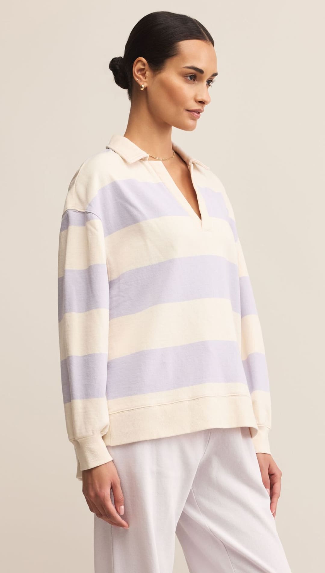 A long-sleeved polo shirt with horizontal cream and light purple stripes.