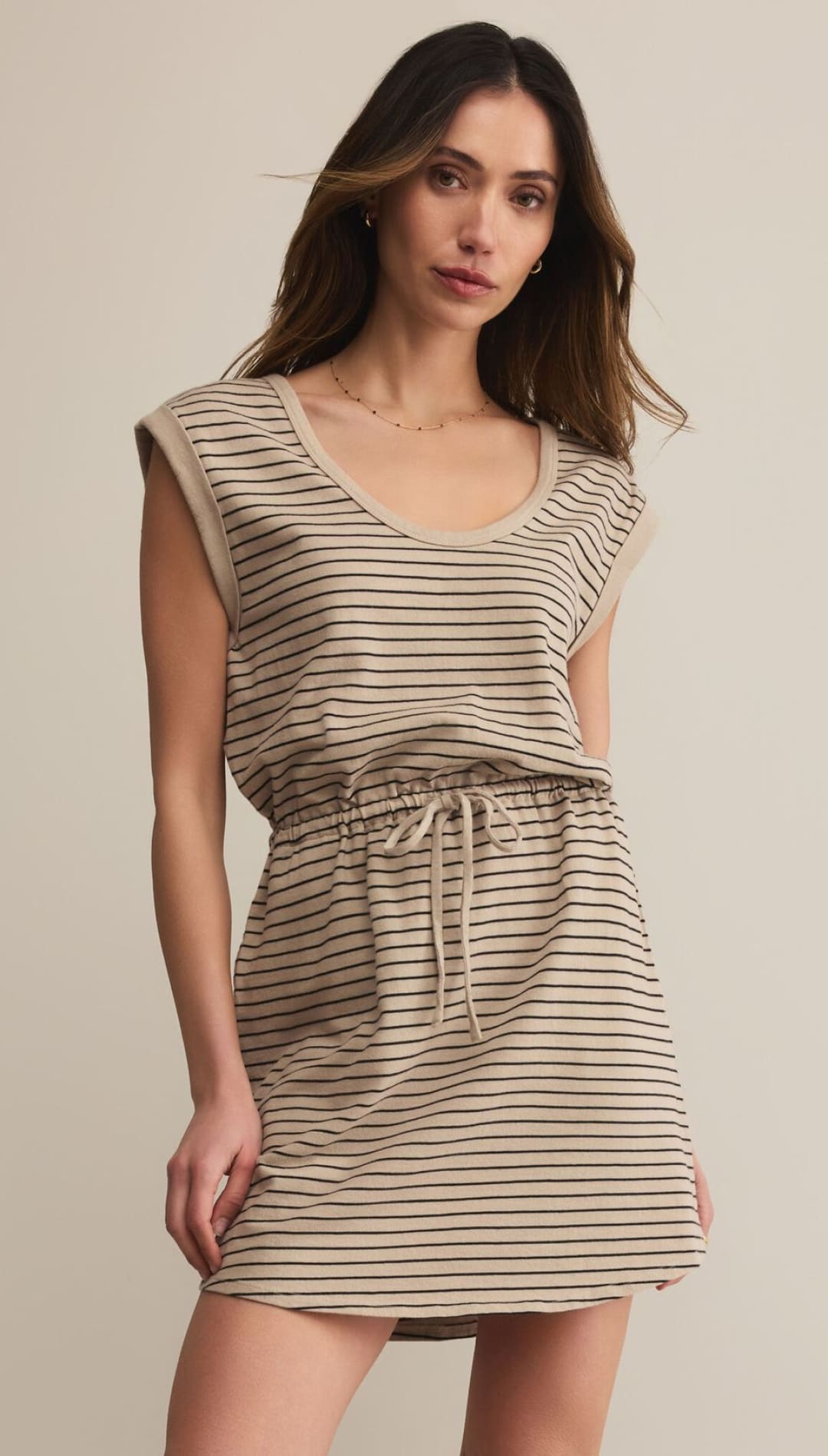 A woman’s beige and black striped drawstring mini-dress with a scoop neck and cap sleeves.