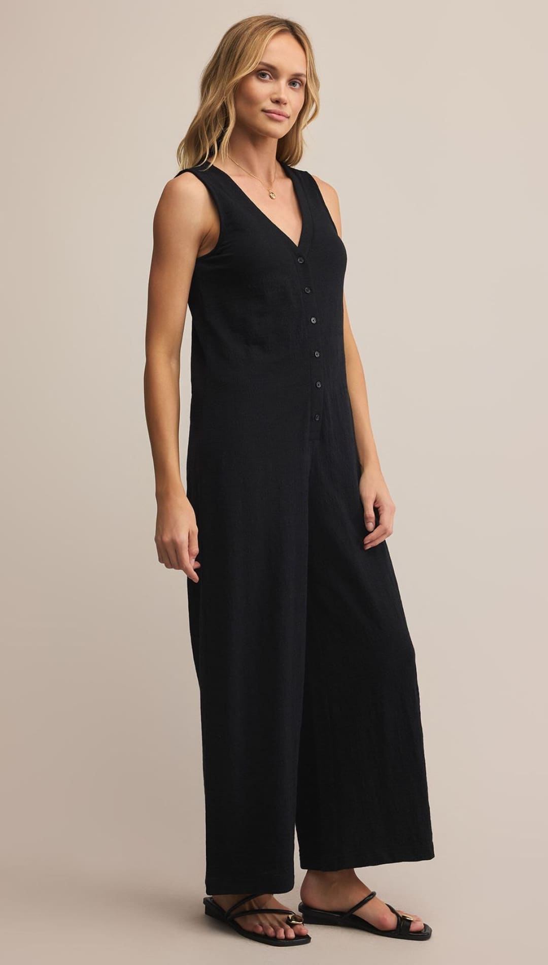 Black sleeveless jumpsuit with button-down front and wide-leg design.