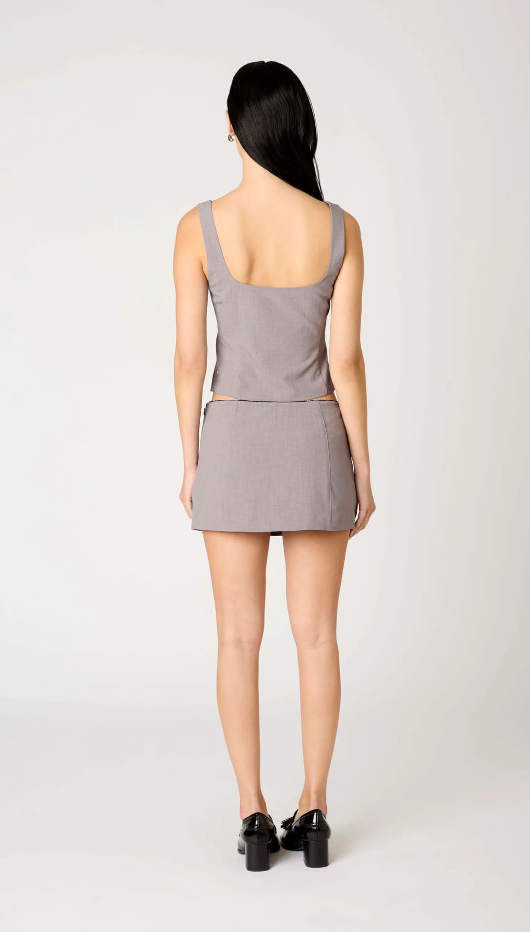 A woman’s sleeveless, square-neck top and mini skirt in a matching gray color.